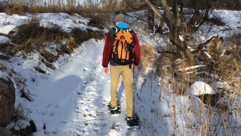 Man snowshoeing on a trail